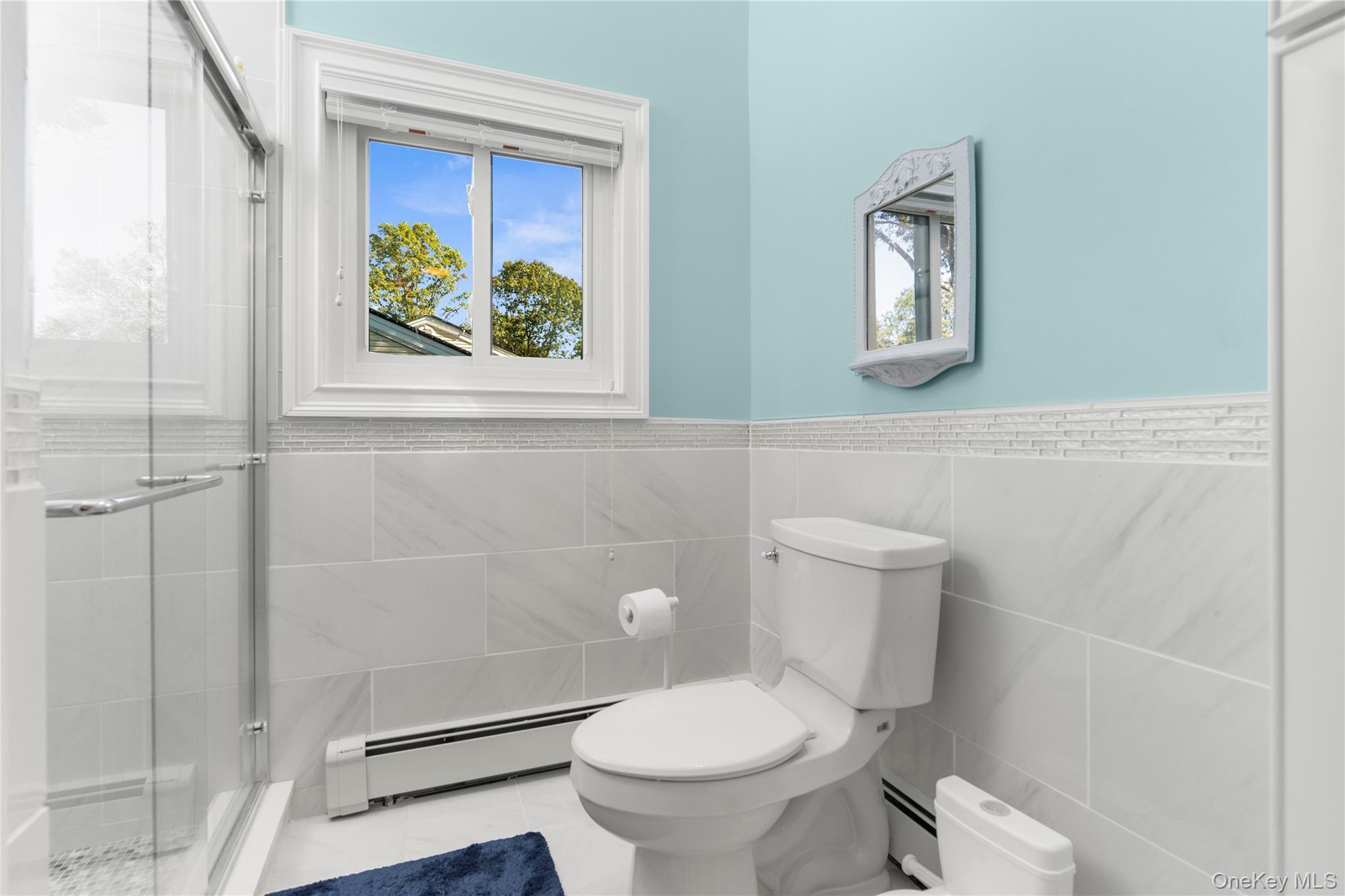 28 Annandale Road Commack, NY 11725 - Photo 22 of 29 Full bathroom with double vanity, a shower with curtain, tile walls and light tile patterned floors.