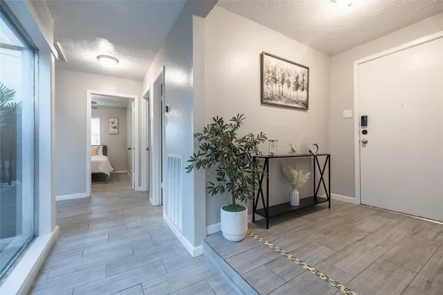 a view of a hallway with wooden floor and a living room
