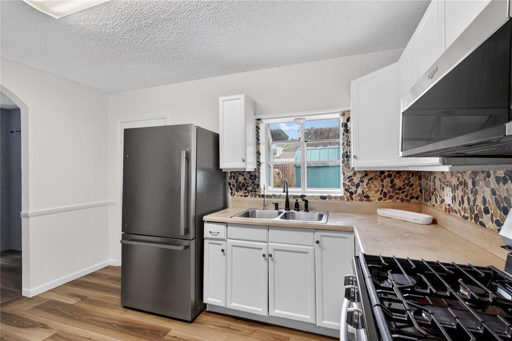 521 Michigan Street Mount Dora, FL 32757 - Photo 7 of 27 a kitchen with a refrigerator sink and microwave