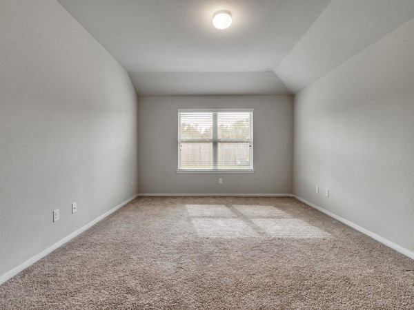 2939 Canadian Goose Lane Baytown, TX 77521 - Photo 24 of 48 This photo shows a spacious, carpeted room with neutral walls and a ceiling light. A window lets in natural light, creating a bright and inviting atmosphere. Perfect for a bedroom or office space.