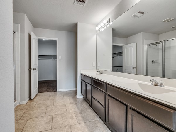 2939 Canadian Goose Lane Baytown, TX 77521 - Photo 26 of 48 a spacious bathroom with a double vanity sink double and a mirror