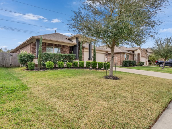 2939 Canadian Goose Lane Baytown, TX 77521 - Photo 7 of 44 Charming single-story 3/4 Bedroom brick home with a spacious driveway, well-maintained lawn, and mature landscaping. The property's exterior features a two-car garage and a cozy front porch, perfect for relaxing.