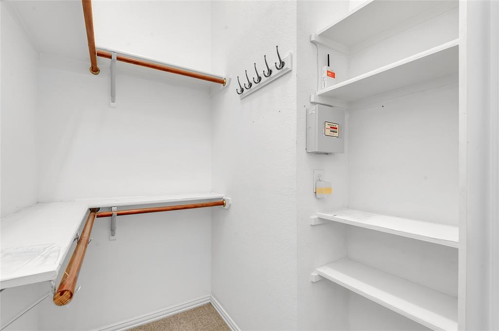 1404 Ranch Hill Drive Irving, TX 75063 - Photo 27 of 31 Well-appointed closet featuring multiple hanging rods, integrated shelving, and wall-mounted hooks