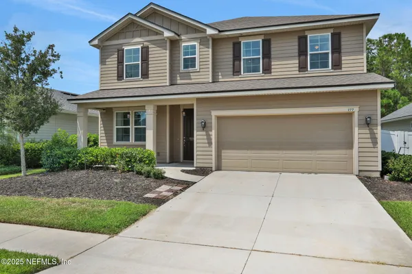 a front view of a house with a yard and garage