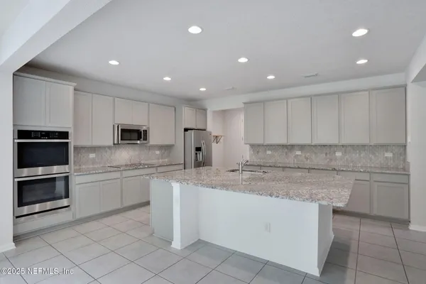 a kitchen with granite countertop a refrigerator and a stove