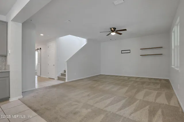 a view of an empty room with a ceiling fan