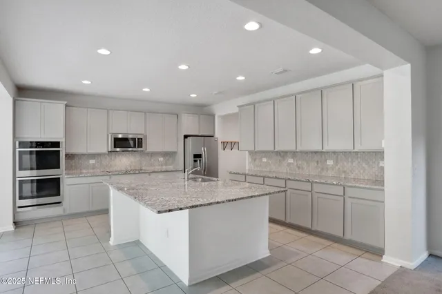 a kitchen with stainless steel appliances granite countertop a sink and cabinets