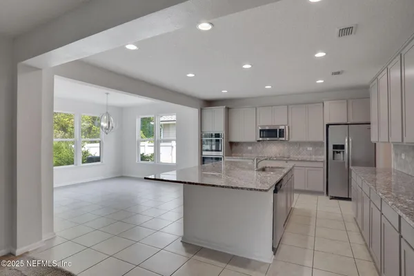 a kitchen with stainless steel appliances granite countertop a refrigerator and a stove top oven