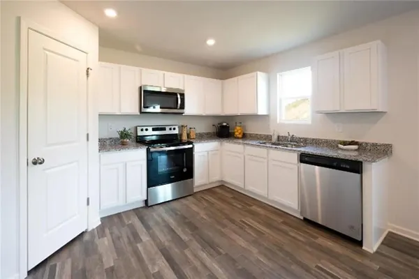 a kitchen with stainless steel appliances granite countertop a stove a sink and a refrigerator