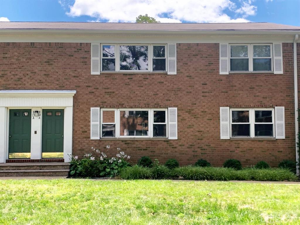 a view of a brick house with a yard and large window