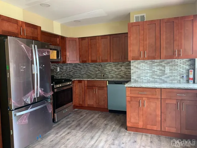 a kitchen with granite countertop stainless steel appliances and wooden cabinets