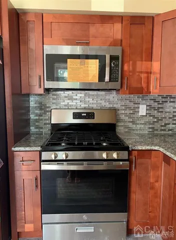 a stove top oven sitting inside of a kitchen and granite counter tops