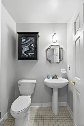 a bathroom with a toilet sink and mirror