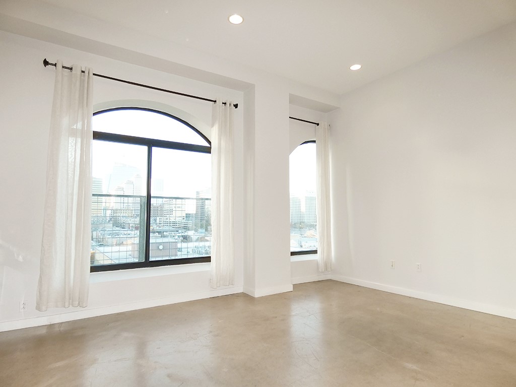 an empty room with windows and mirror