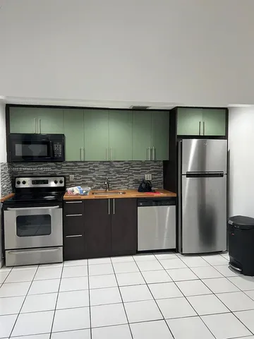 a kitchen with a refrigerator and a stove top oven