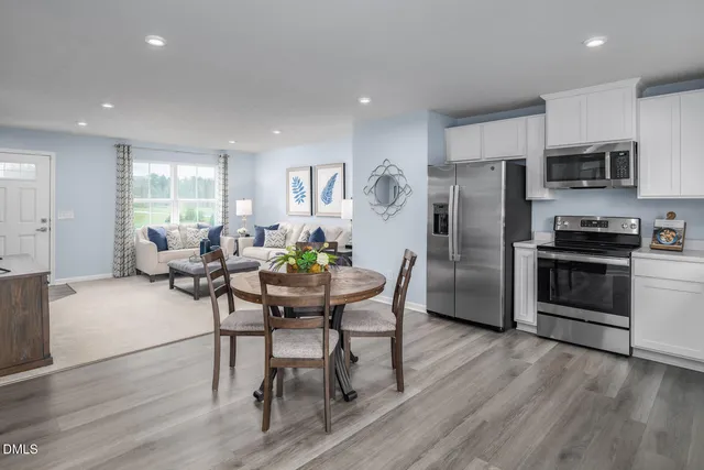 a kitchen with refrigerator cabinets dining table and chairs