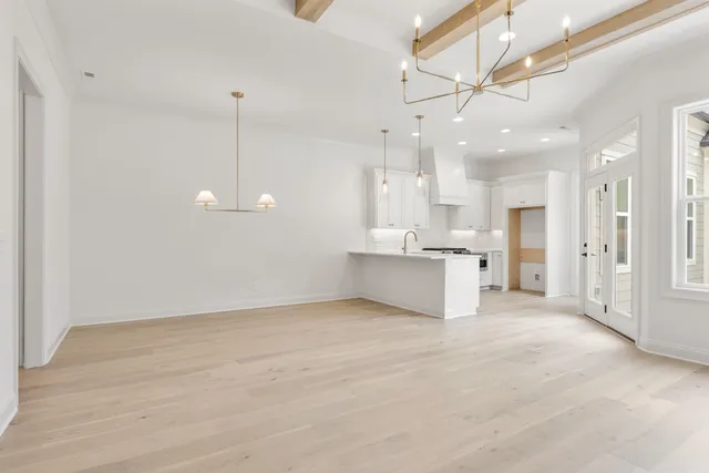 a view of an empty room and kitchen view