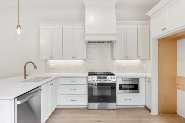 a kitchen with white cabinets and appliances