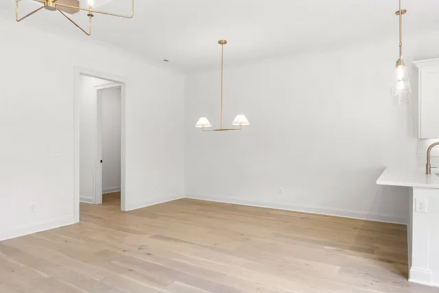 a view of a room with wooden floor and ceiling fan
