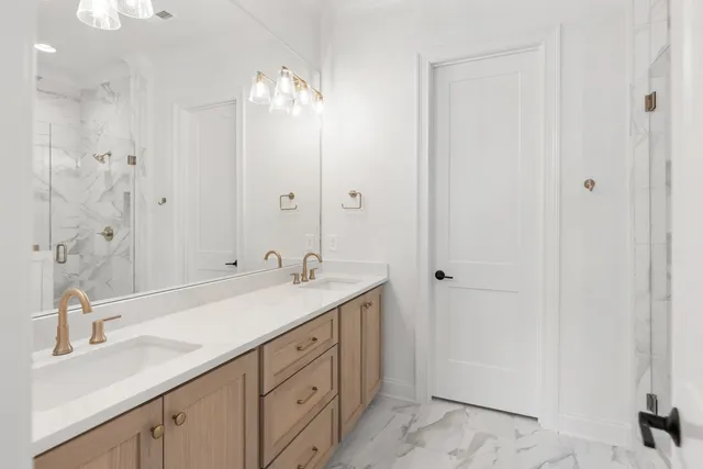 a spacious bathroom with a double vanity sink a large mirror and shower