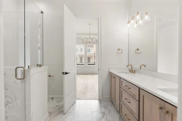 a bathroom with a granite countertop sink a mirror and a shower