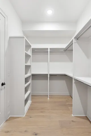 a view of walk in closet with empty racks