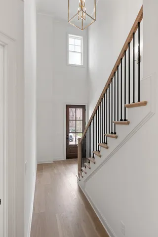 a view of a hallway with wooden floor and stairs