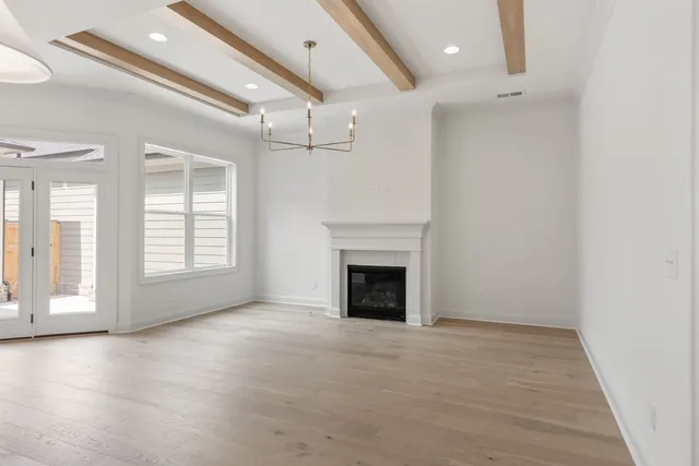 a view of an empty room with a fireplace and a window