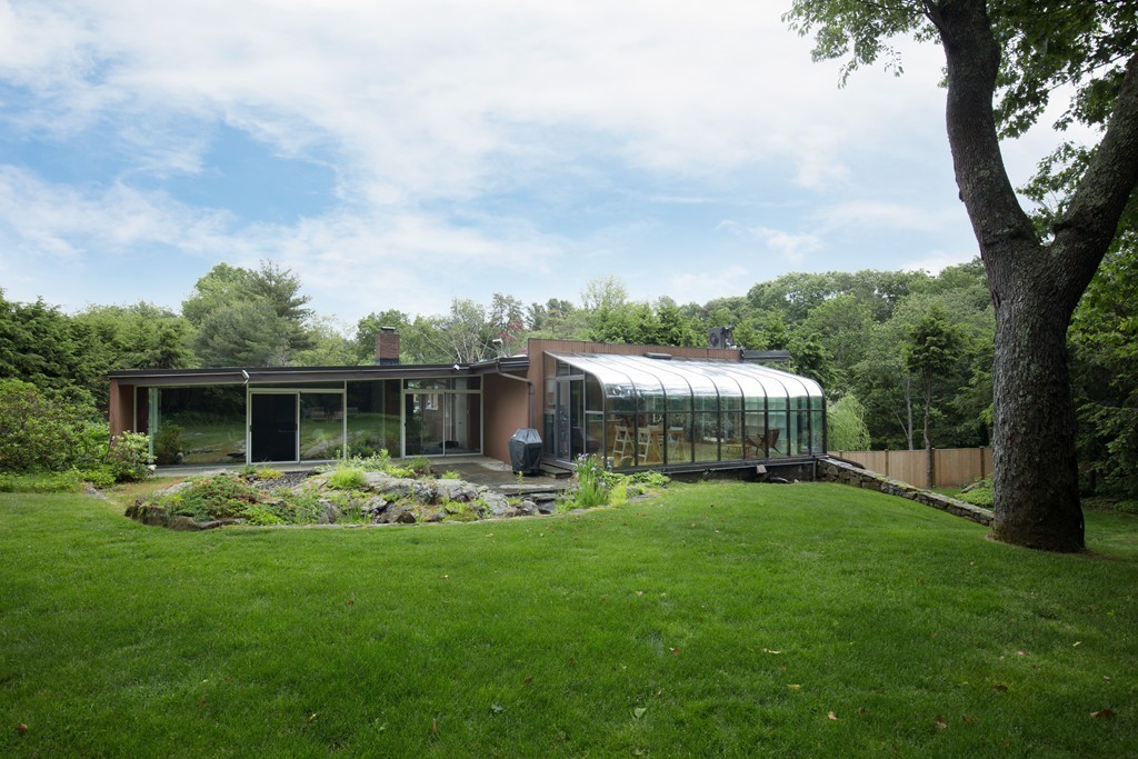 a front view of house with garden and trees