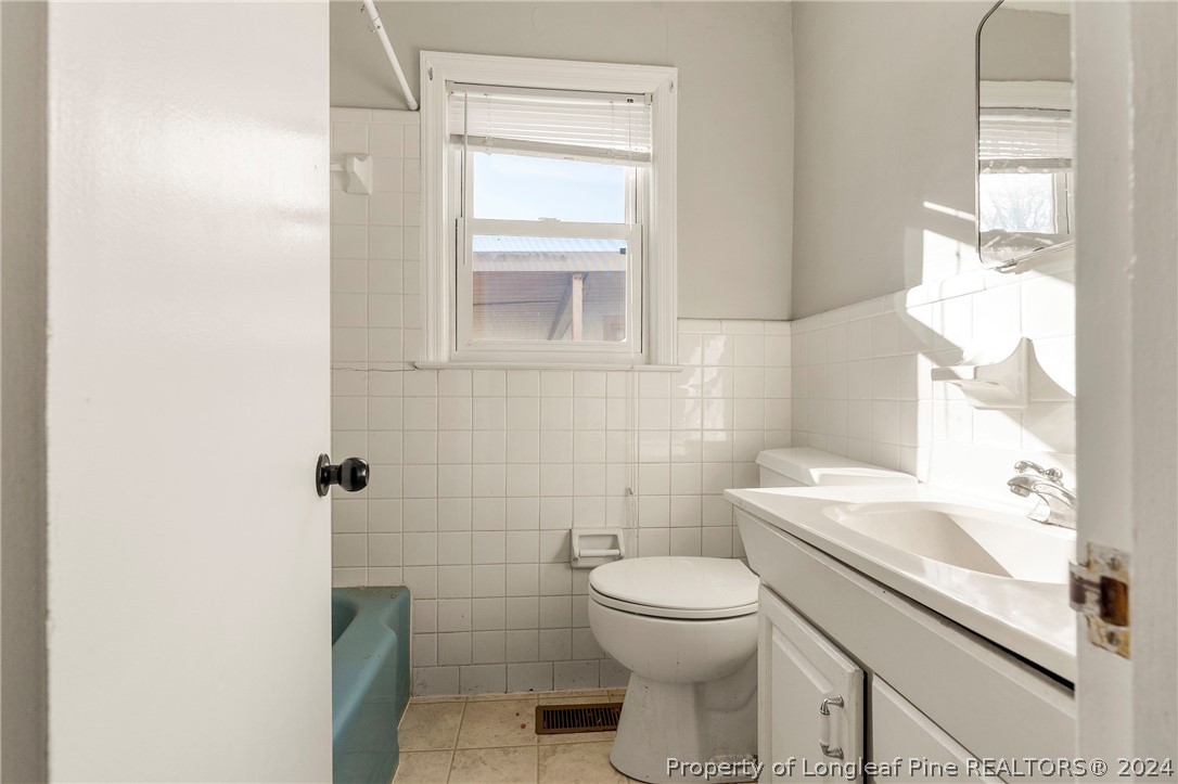 1700 Cedar Creek Road Fayetteville, NC 28312 - Photo 15 of 21 a white toilet sitting next to a bathroom sink