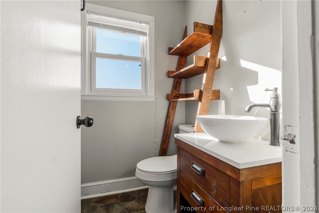 1700 Cedar Creek Road Fayetteville, NC 28312 - Photo 16 of 21 a bathroom with a sink a toilet and mirror