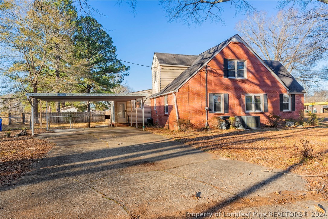 1700 Cedar Creek Road Fayetteville, NC 28312 - Photo 3 of 21 a view of a white house with a large windows next to a road