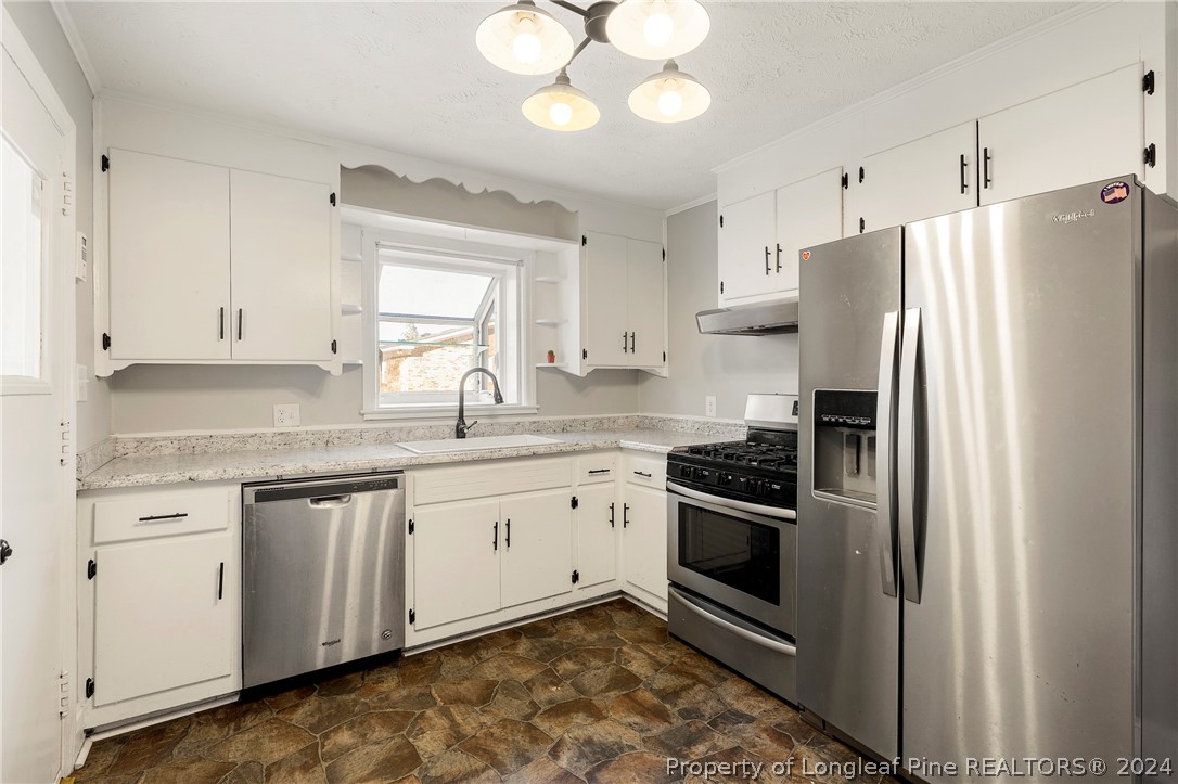 1700 Cedar Creek Road Fayetteville, NC 28312 - Photo 7 of 21 a kitchen with stainless steel appliances granite countertop a refrigerator a sink dishwasher a stove and white cabinets with wooden floor
