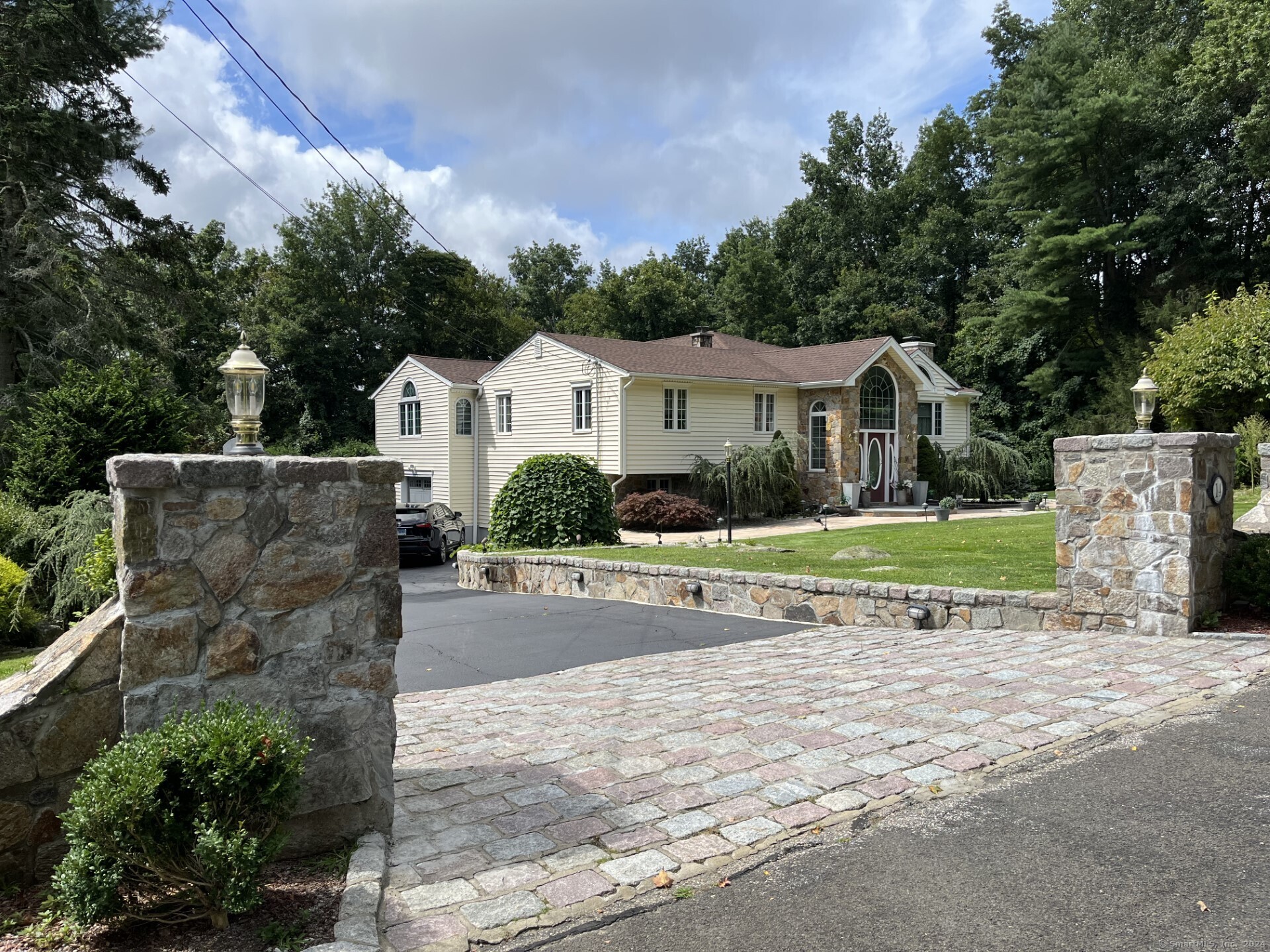 a view of a house with a yard and large tree