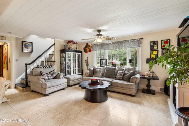 a living room with furniture potted plant and a large window