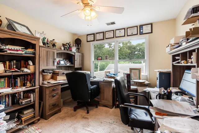 a view of a workspace with furniture and a window