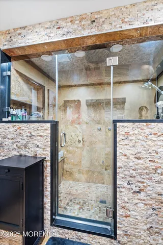 a bathroom with a granite countertop window and a glass door