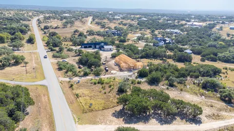 an aerial view of residential houses with outdoor space and trees