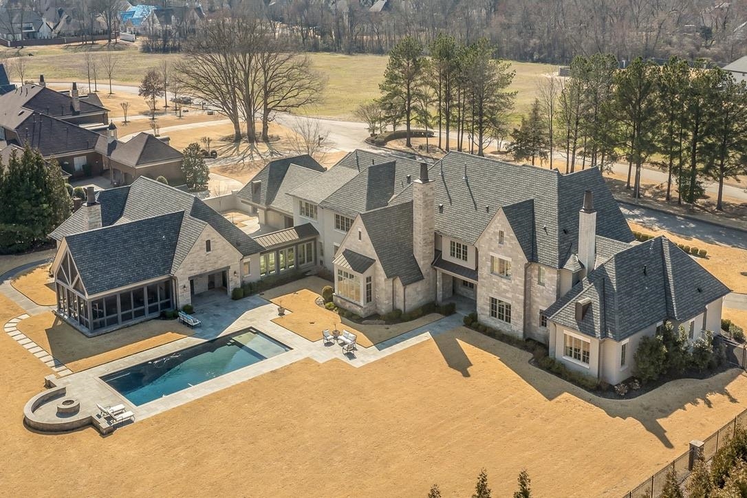 a view of a house with pool and chairs