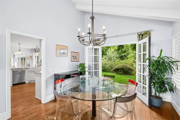 a dining room with furniture a chandelier and wooden floor