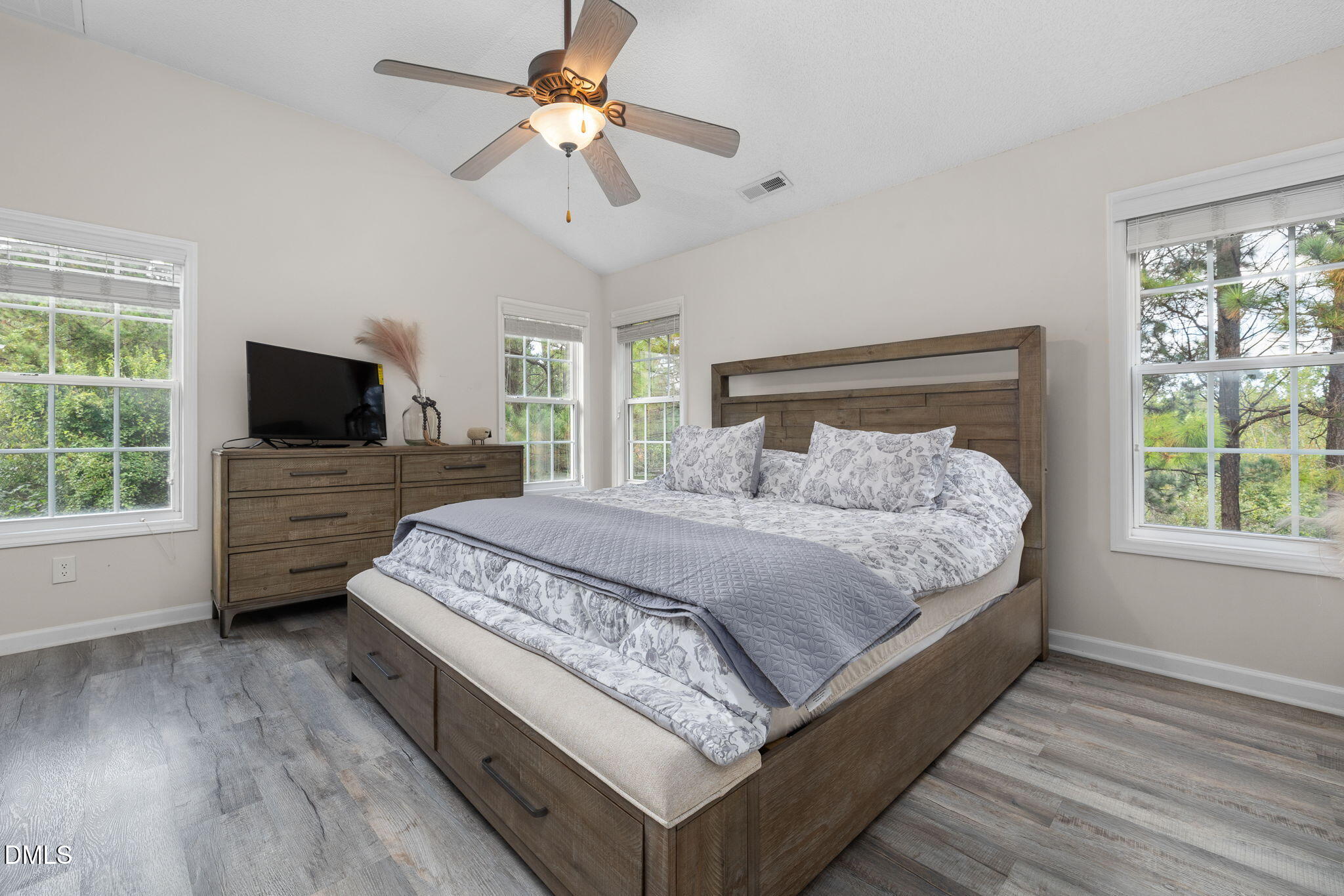 6901 Middleboro Drive Raleigh, NC 27612 - Photo 24 of 42 a spacious bedroom with a bed and a flat tv screen on dresser