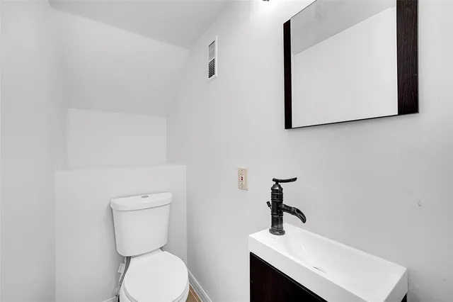 a bathroom with a toilet sink and mirror