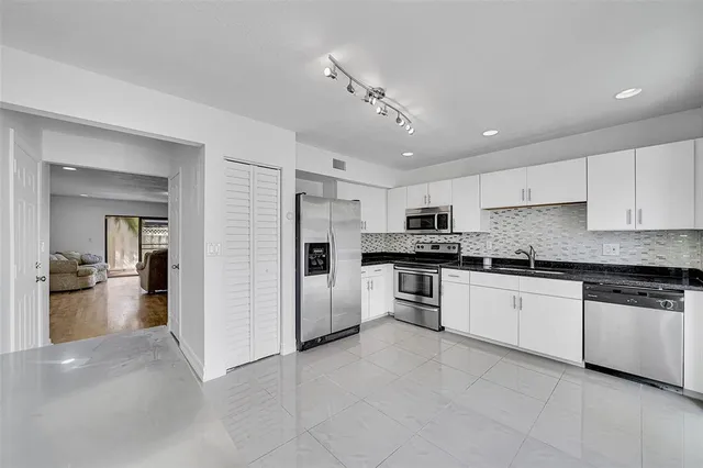 a large kitchen with cabinets and stainless steel appliances
