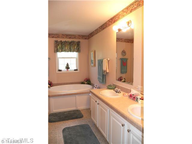 485 Riverview Rd Extension Lexington, NC 27292 - Photo 11 of 16 Master Bath/Spa. Large master bath has 2 sinks with mirrors, separate shower, corner garden tub and walk-in closet - not shown. Frosted window over garden tub lets in natural light but retains privacy.