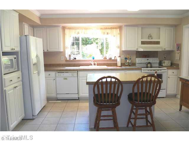 485 Riverview Rd Extension Lexington, NC 27292 - Photo 7 of 16 Kitchen. Kitchen with triple window over sink with lovely view of the back garden and fields. Large island kitchen with 2 kitchen stools. Lots of cabinets for storage. All appliances included. Tile floor in Kitchen and Laundry room to the right.