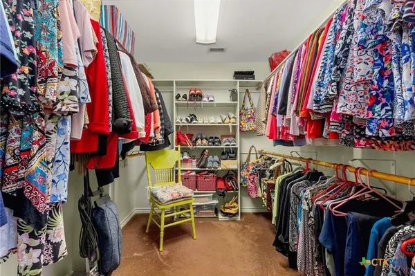 a view of walk in closet with clothes and shoes