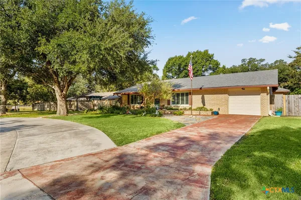 a front view of a house with a yard and trees