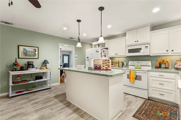 a kitchen with white cabinets and white appliances