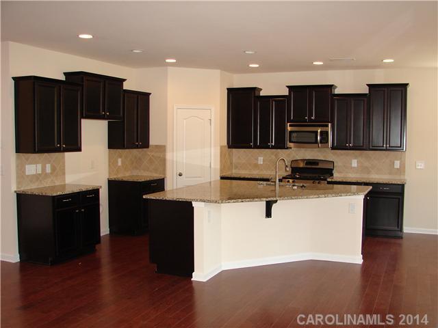 4110 Perth Road, Unit 225 Indian Land, SC 29707 - Photo 4 of 6 a kitchen with stainless steel appliances kitchen island granite countertop a stove a sink a refrigerator and a microwave
