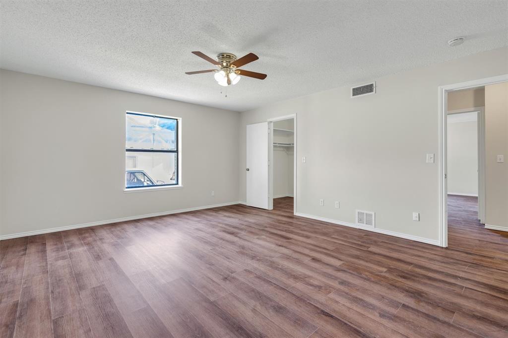 209 Mistletoe Lane Keene, TX 76059 - Photo 18 of 38 an empty room with wooden floor chandelier fan and windows